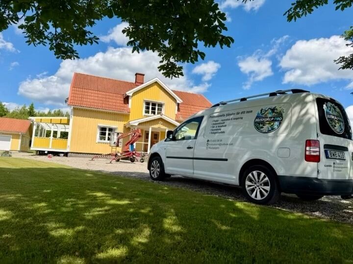 Hushjälp Pros servicebil parkerad framför ett gult hus med skylift